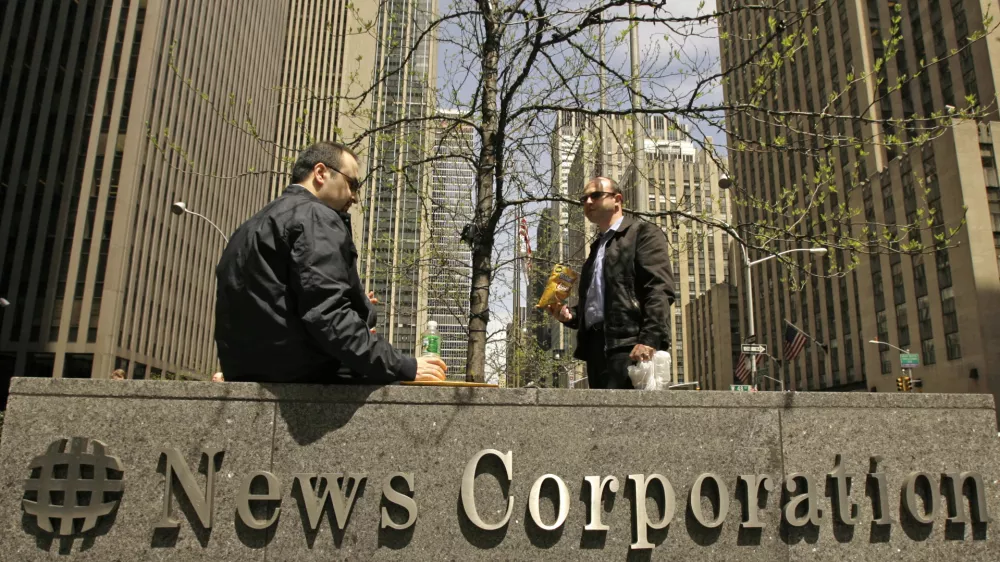 Two men eat lunch while seated outside News Corporation's corporate headquarters, Tuesday, May 1, 2007 in New York. Dow Jones & Co., publisher of the Wall Street Journal, said Tuesday it received an unsolicited bid from Rupert Murdoch's News Corporation to buy the company for $5 billion. The news sent shares of News Corp. soaring and those of other newspaper higher. (AP Photo/Kathy Willens)