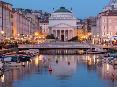 View of the Ponte Rosso bridge and the Church of St. Anthony the Thaumaturge reflected in the canal in the heart of Trieste, Italy.