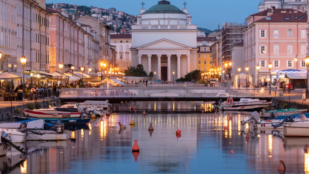 View of the Ponte Rosso bridge and the Church of St. Anthony the Thaumaturge reflected in the canal in the heart of Trieste, Italy.