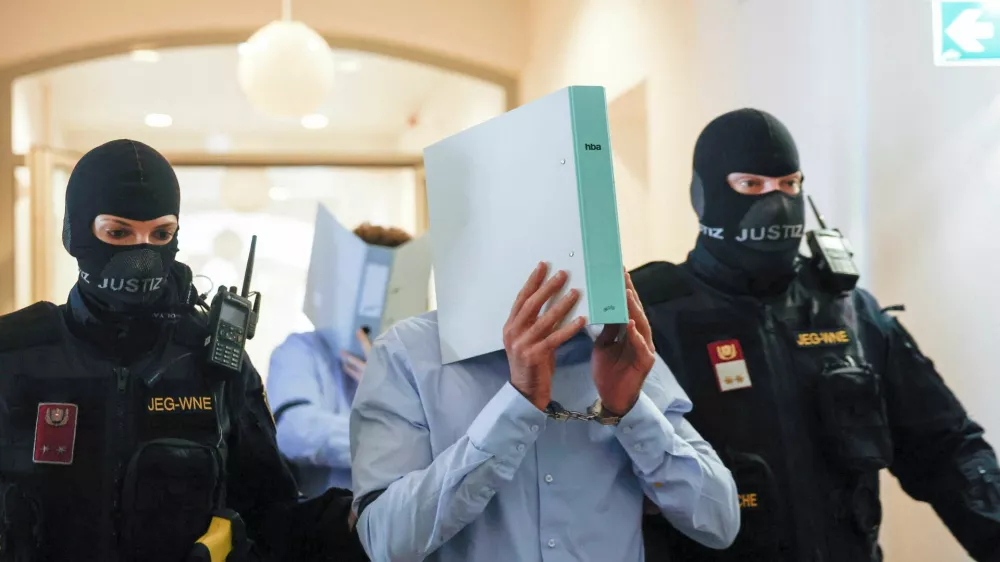 Austrian defendant identified as Beran A, suspected of planning an attack on U.S. singer Taylor Swift's Vienna concert in 2024, is escorted by security personnel in a courtroom for his trial in Wiener Neustadt, Austria, May 28, 2026. REUTERS/Lisa Leutner   TPX IMAGES OF THE DAY