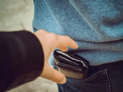one hand reaches for a purse in the back pocket