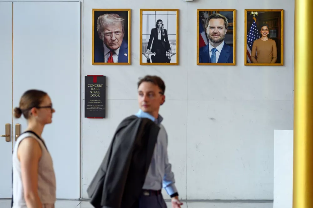 A couple walks past the Concert Hall stage door and portraits of President Donald Trump, first lady Melania Trump, Vice President JD Vance and second lady Usha Vance, at The John F. Kennedy Center for Performing Arts is seen in Washington, Friday, May 29, 2026. (AP Photo/Cliff Owen)
