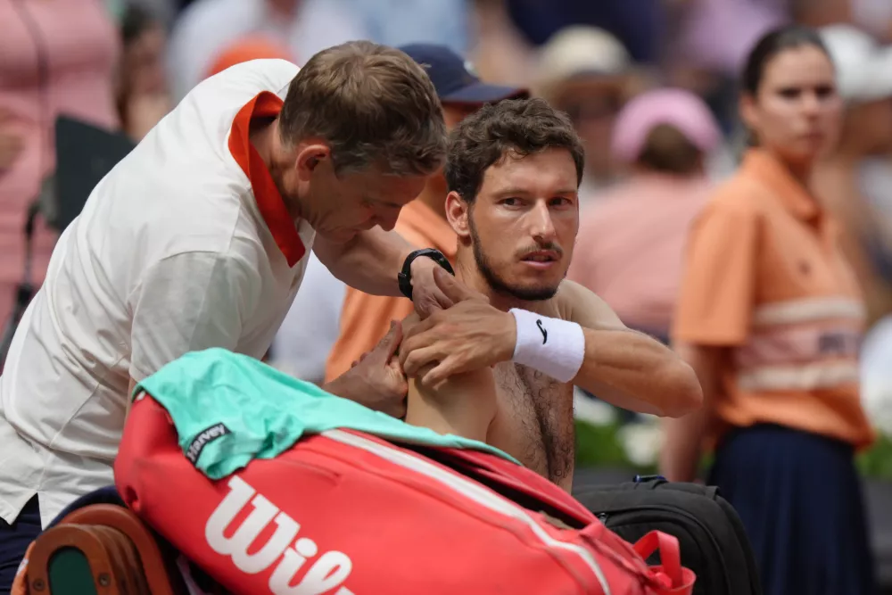 Spain's Pablo Carreno Busta is treated for shoulder injury during the fourth-round tennis match againt Spain's Rafael Jodar at the French Open in Paris, Sunday, May 31, 2026. (AP Photo/Aurelien Morissard)