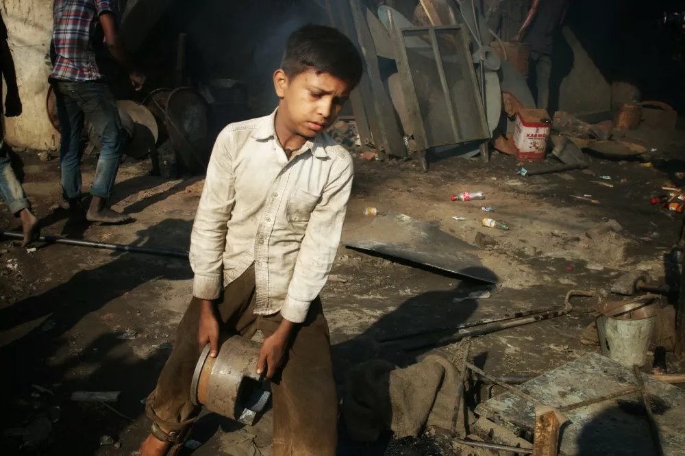 A young boy works as a child labourer at a dockyard in Keraniganj near Dhaka.There are twenty-eight dockyards occupying 30.96 acres of the Buriganga foreshore where ships, launches, and steamers of various sizes and shapes are built and repaired. They have continued to operate for the last 50 years without any authorization or guidelines, thus polluting the river and encroaching into the riverbank, reducing its navigability.Daily life at a dockyard in Keraniganj, Bangladesh - 22 Jun 2020,Image: 534632875, License: Rights-managed, Restrictions:, Model Release: no 