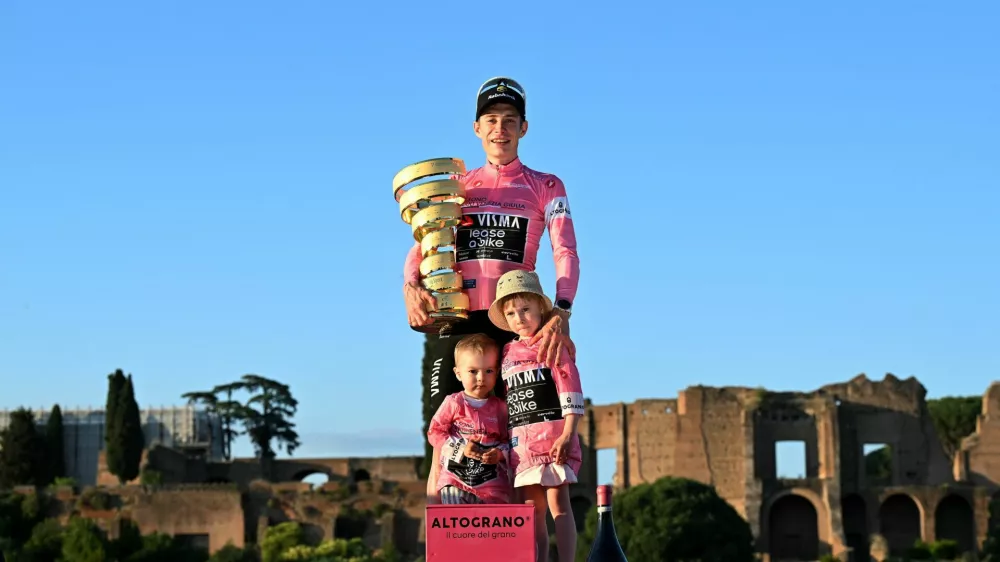 Cycling - Giro d'Italia - Stage 21 - Rome to Rome - Italy - May 31, 2026 Team Visma - Lease a Bike's Jonas Vingegaard celebrates on the podium with his daughter Frida, his son, and the trophy wearing the maglia rosa jersey after winning the Giro d'Italia REUTERS/Jennifer Lorenzini