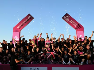 Cycling - Giro d'Italia - Stage 21 - Rome to Rome - Italy - May 31, 2026 Team Visma - Lease a Bike's Jonas Vingegaard celebrates on the podium with his daughter Frida, Team Visma - Lease a Bike CEO and general manager Richard Plugge, and teammates wearing the maglia rosa jersey after winning the Giro d'Italia REUTERS/Jennifer Lorenzini