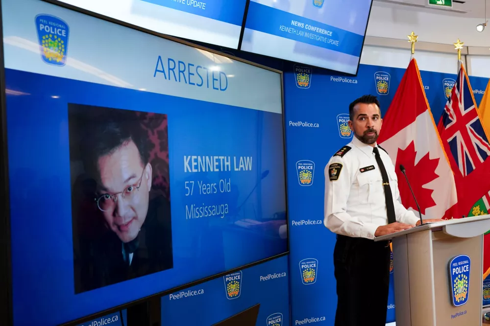 FILE - York Regional Police Inspector Simon James speaks during a news conference in Mississauga, Ont., Aug. 29, 2023, with the image of Kenneth Law, a Canadian man accused of selling lethal substances on the internet to people at risk of self harm, displayed on screen. (Arlyn McAdorey/The Canadian Press via AP, File)