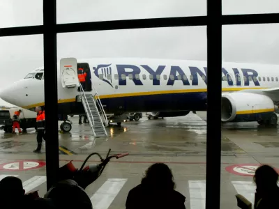 FILE PHOTO: Travellers wait in front of a passenger jet belonging to Irish discount airline Ryanair at Charleroi airport in southern Belgium, February 2, 2004. REUTERS/Yves Herman/File Photo     GLOBAL BUSINESS WEEK AHEAD   SEARCH GLOBAL BUSINESS 24 JUL FOR ALL IMAGES
