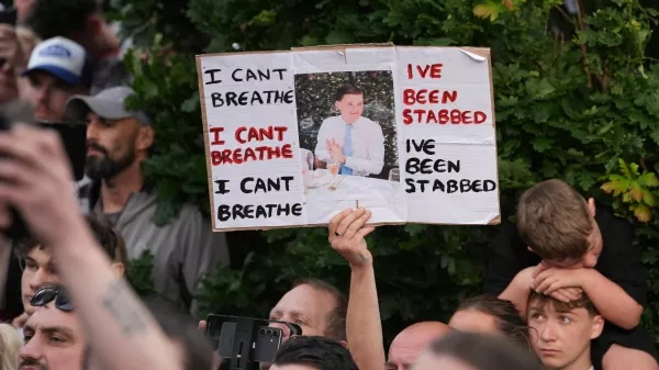 People protest outside the police station in Southampton, England, on Tuesday, June 2, 2026, one holding a photo of December 2025 stabbing victim Henry Nowak, 18. (Gareth Fuller/PA via AP)
