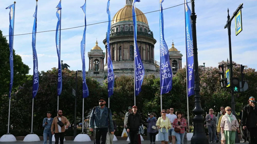 People cross the street near flags with the logo of the St. Petersburg International Economic Forum (SPIEF) flying in front of the St. Isaac's Cathedral on the eve of the forum's opening in Saint Petersburg, Russia June 2, 2026. REUTERS/Anastasia Barashkova