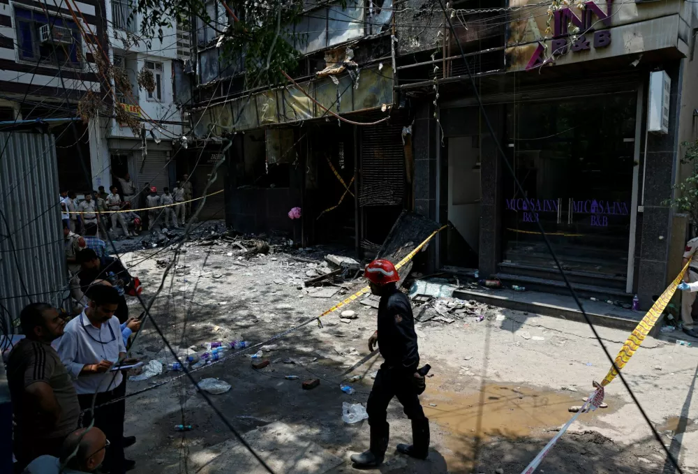 Firefighters and police officers work at the site after a fire at a hotel in New Delhi, India, June 3, 2026. REUTERS/Adnan Abidi