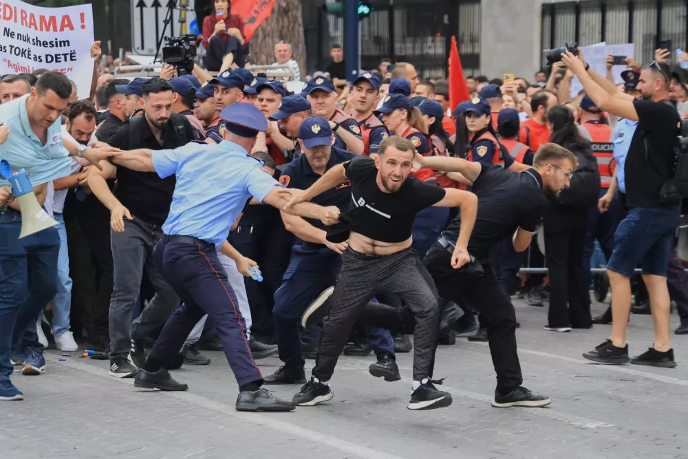 Protesters scuffle with police officers blocking a street during a demonstration in Tirana, Albania, Wednesday, June 3, 2026, opposing a luxury coastal development project linked to Jared Kushner and Ivanka Trump over concerns about environmental impacts and transparency. (AP Photo/Hameraldi Agolli)