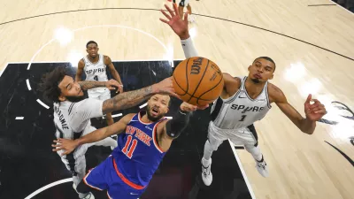 Jun 5, 2026; San Antonio, Texas, USA; New York Knicks guard Jalen Brunson (11) drives to the basket past San Antonio Spurs forward Julian Champagnie (30) and forward Victor Wembanyama (1) during game two of the 2026 NBA Finals at Frost Bank Center. Mandatory Credit: Gregory Shamus-Pool Photo via Imagn Images