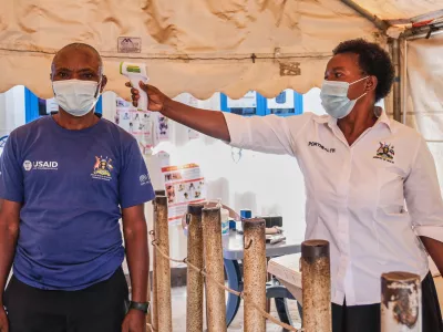 A health worker checks an individual's temperature at a temporary health clinic at the Mpondwe border crossing linking Uganda and the Democratic Republic of the Congo, Thursday, June 4, 2026. (AP Photo/Hajarah Nalwadda)