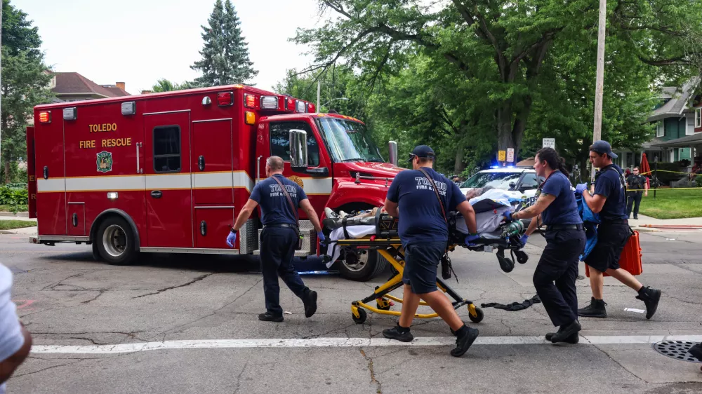 First responders help a woman who was injured at the mass shooting that left people injured at the Old West End Festival at the Agnes Reynolds Jackson Arboretum in Toledo, Ohio on Saturday, June 6, 2026. (Rebecca Benson/The Blade via AP)