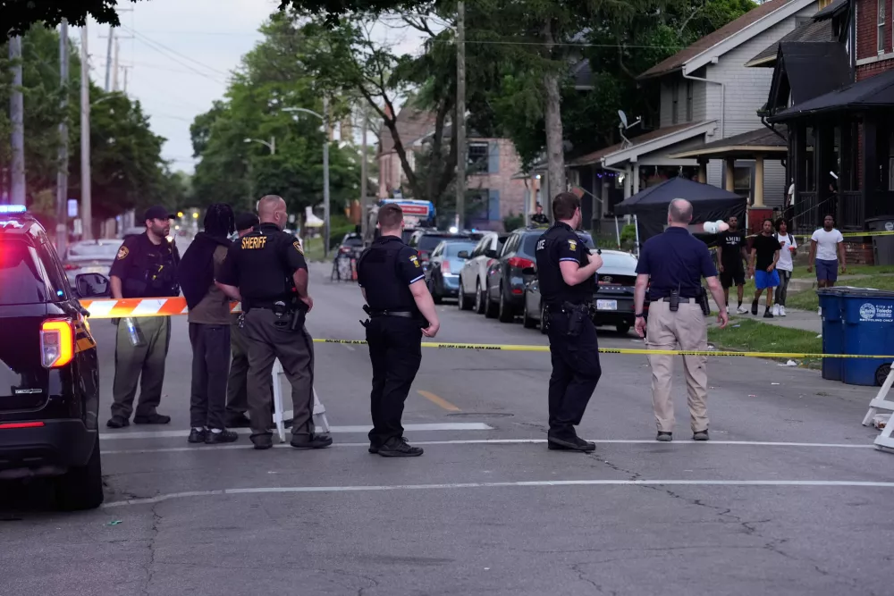 Police stand near where multiple people were shot at a community festival Saturday, June 6, 2026, in Toledo, Ohio. (AP Photo/Paul Sancya)