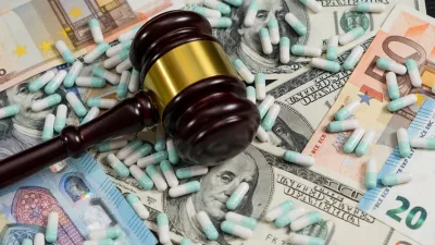 Wood judge's gavel and scattered colorful drugs on the dollar and euro cash background, drugs falsification, concept for medical negligence, bail. Overhead view.