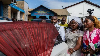 A newly married couple and guests wait outside the civil registry office amid an Ebola outbreak in Ituri Province in Bunia, Congo, Saturday, June 6, 2026. (AP Photo/Moses Sawasawa)
