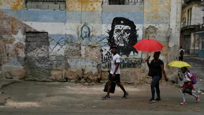 People walk past an image of late revolutionary Ernesto "Che" Guevara painted on a wall, as Cuba reconnected its electrical grid across much of the island, according to the Energy and Mines Ministry, following a nationwide blackout that left about 10 million people without electricity, in Havana, Cuba, March 17, 2026. REUTERS/Norlys Perez