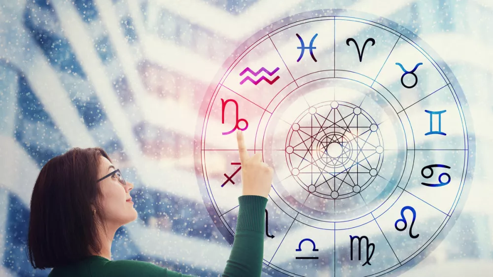 Woman choosing a zodiac sign from the astrological wheel to find the future predictions. Having trust in horoscope, consulting stars and believe in the power of universe. Astrology esoteric concept.