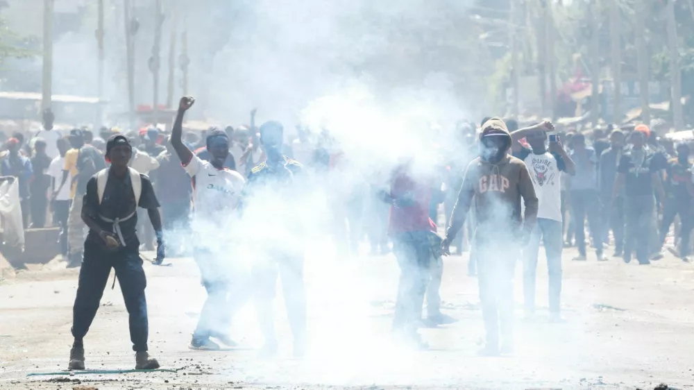 Demonstrators react after riot police lobbed tear gas cannisters to disperse during a protest against a U.S.-backed Ebola quarantine plan to establish a 50-bed facility at a Kenyan air force base intended to host Americans exposed to Ebola, in Nanyuki town, Laikipia County, Kenya, June 9, 2026. REUTERS/Monicah Mwangi