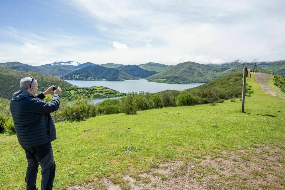 Tourists enjoy beautiful views of the Picos de Europa from atop a hill in Ria&ntilde;o, in spring, with free-roaming horses and the Ria&ntilde;o reservoir, Le&oacute;n, Castilla y Le&oacute;n, Spain - May 2, 2025. / Foto: Alberfb