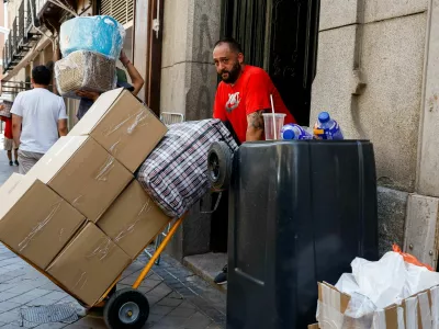 A worker transports boxes and a bag during a heatwave in Madrid, Spain, July 6, 2026. REUTERS/Violeta Santos Moura / Foto: Violeta Santos Moura