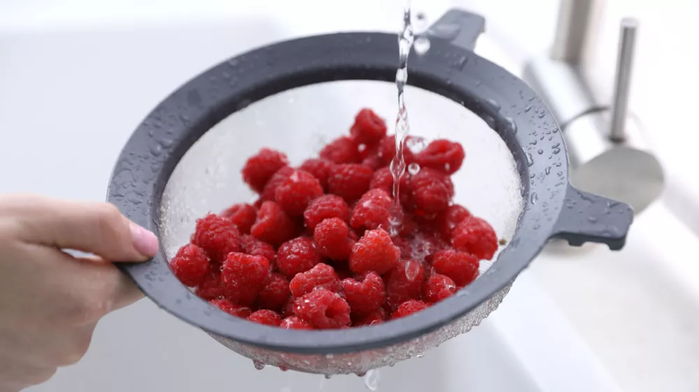 Woman washing raspberries in sieve at sink, closeup / Foto: Olga Yastremska Getty Images
