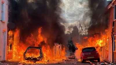 Vehicles set on fire by protesters burn on Lendrick Street in east Belfast, Northern Ireland, on Tuesday, June 9, 2026, after the arrest of a Sudanese man accused of stabbing a man in the northern part of the city. (PA via AP)