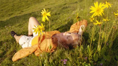 Austria, woman lying in meadow