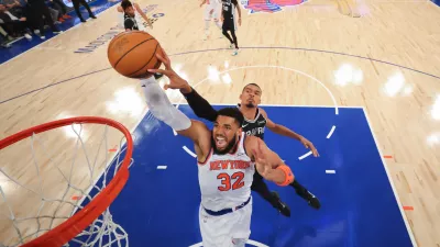 New York Knicks center Karl-Anthony Towns (32) dunks past San Antonio Spurs forward Victor Wembanyama during the first half of Game 4 of the NBA Finals basketball series, Monday, June 8, 2026, in New York. (Al Bello/Pool Photo via AP)