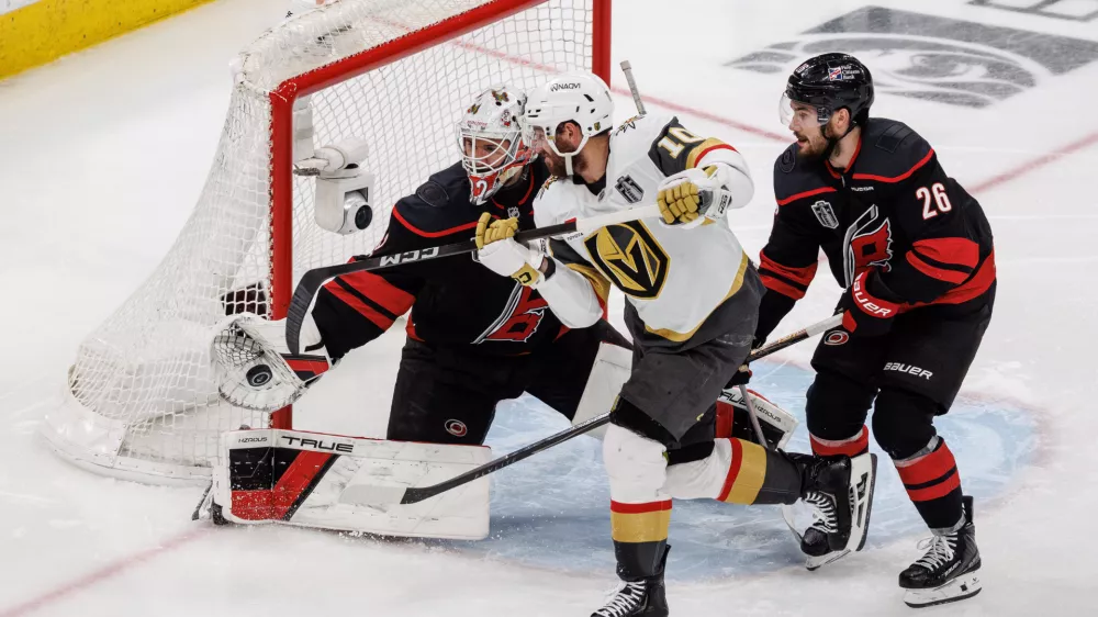 Carolina Hurricanes' Brandon Bussi (32) reaches for the puck ahead of Sean Walker (26) as Vegas Golden Knights' Colton Sissons (10) attempts a shot during the third period of Game 5 of the NHL hockey Stanley Cup Final series in Raleigh, N.C., Thursday, June 11, 2026. (AP Photo/Ben McKeown)