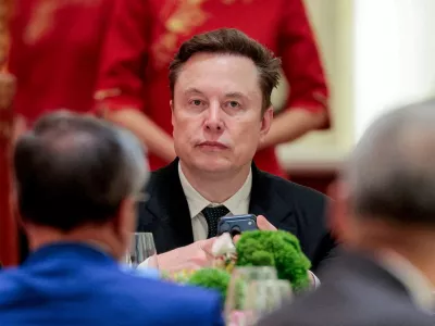 FILE PHOTO: Tesla CEO Elon Musk holds a mobile phone as he arrives to attend a state banquet with U.S. President Donald&nbsp;Trump and Chinese President Xi Jinping at the Great Hall of the People in Beijing, China, May 14, 2026. REUTERS/Evan Vucci//File Photo