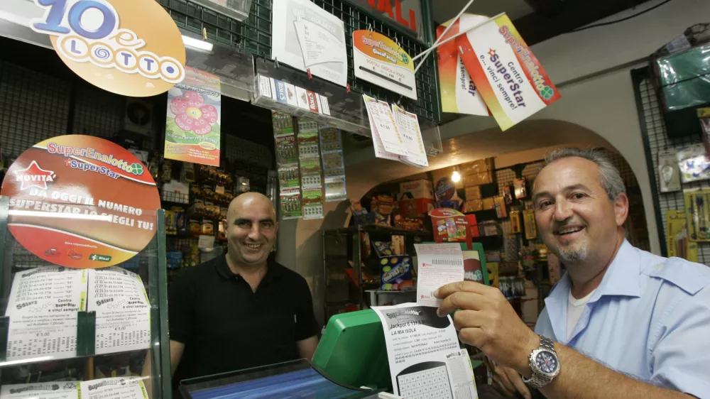 An unidentified man, right, shows his SuperEnalotto lottery ticket at a betting center in Castel Gandolfo, on the outskirts of Rome, Wednesday, Aug. 12, 2009. The record jackpot for Italy's state lottery increased to euro 131.5 million ($186.2 million) after the latest drawing Tuesday again thwarted those hoping to get the winning, six-number combination. No one has hit the jackpot in the SuperEnalotto game since January, causing the prize to increase to the highest level in Italy's and Europe's history. The next drawing is Thursday. (AP Photo/Pier Paolo Cito)