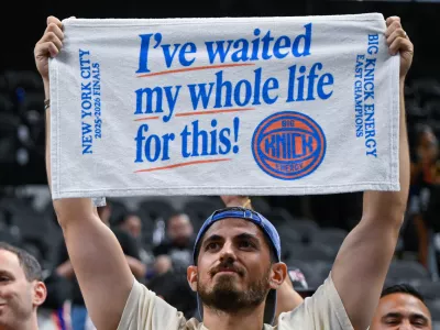 A New York Knicks fan celebrates after the Knicks defeated the San Antonio Spurs in Game 5 of the NBA Finals basketball series, Saturday, June 13, 2026, in San Antonio. (AP Photo/Darren Abate)