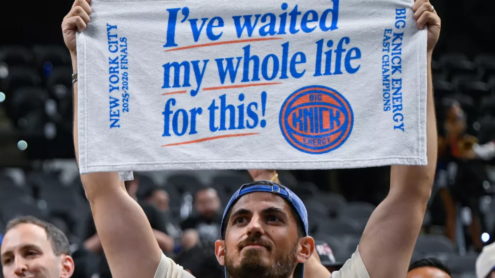 A New York Knicks fan celebrates after the Knicks defeated the San Antonio Spurs in Game 5 of the NBA Finals basketball series, Saturday, June 13, 2026, in San Antonio. (AP Photo/Darren Abate)