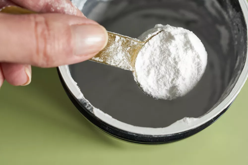 A spoonful of creatine powder in a metal jar, close-up. Female athlete taking creatine from the jar. / Foto: Natalia Rusanova Getty Images