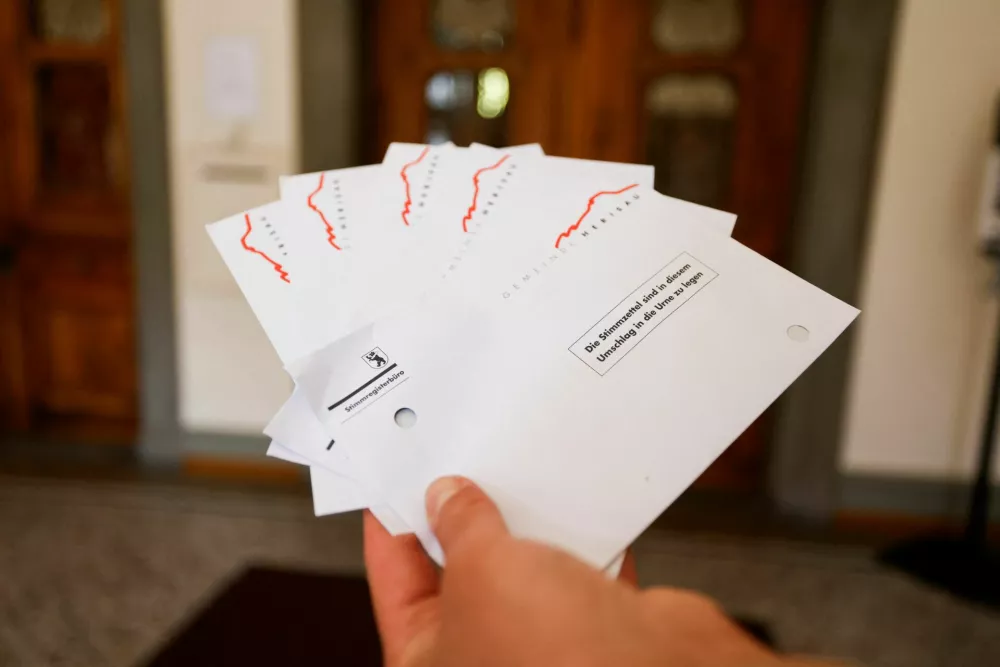 A person holds ballots on the day of the vote on a plan backed by the right-wing Swiss People's Party (SVP) to limit population growth to 10 million inhabitants, in Herisau, Switzerland, June 14, 2026. REUTERS/Michaela Stache