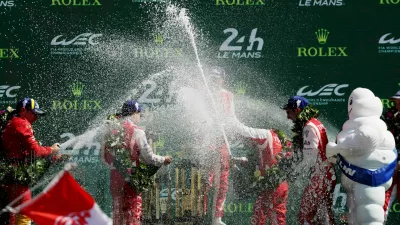The 24 Hours of Le Mans - Circuit de la Sarthe, Le Mans, France - June 14, 2026 Toyota Racing's Mike Conway, Kamui Kobayashi, and Nyck de Vries celebrate on the podium with champagne and team members after winning the 24 Hours of Le Mans REUTERS/Stephane Mahe