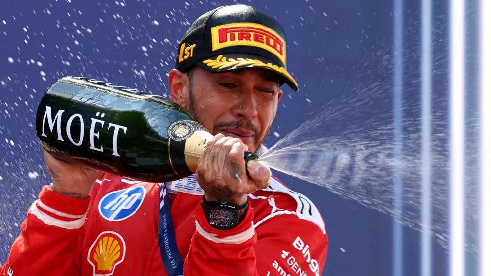Formula One F1 - Barcelona-Catalunya Grand Prix - Circuit de Barcelona-Catalunya, Barcelona, Spain - June 14, 2026 Ferrari's Lewis Hamilton celebrates on the podium with champagne after winning the Barcelona-Catalunya Grand Prix REUTERS/Bruna Casas   TPX IMAGES OF THE DAY