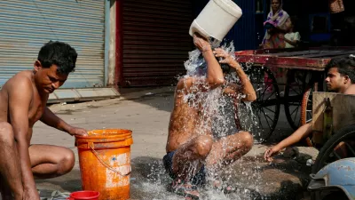 Indian rickshaw driver bathes from a roadside water tap during a hot summer day in Lucknow, northern Indian state of Utter Pradesh, Monday, June 15, 2026. (AP Photo/Rajesh Kumar Singh)