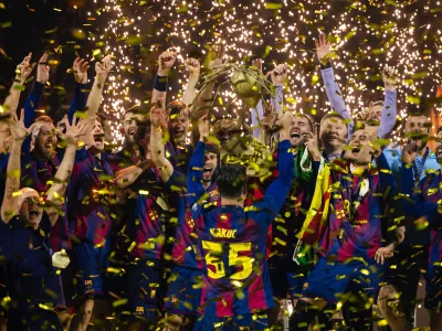 Barcelona players celebrate winning the men's handball Champions League final match between F&uuml;chse Berlin and FC Barcelona in Cologne, Germany, Sunday June 14, 2026. (Marius Becker/dpa via AP)