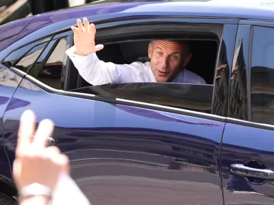 French President Emmanuel Macron waves from a car leaving after meeting security forces ahead of G7 summit in Evian-les-Bains, France, Monday, June 15, 2026. (AP Photo/Christophe Ena)