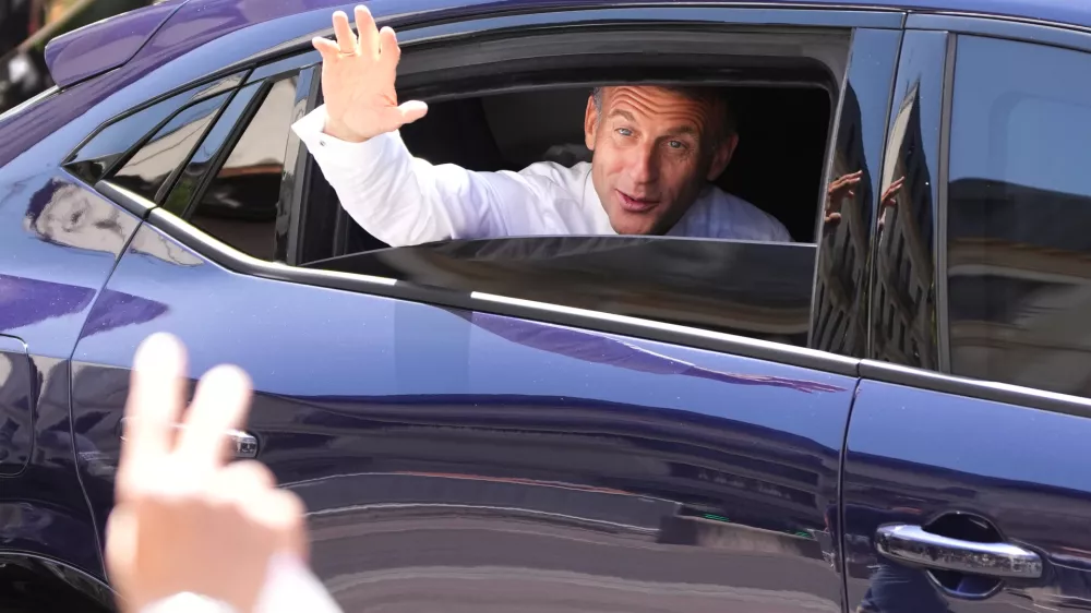 French President Emmanuel Macron waves from a car leaving after meeting security forces ahead of G7 summit in Evian-les-Bains, France, Monday, June 15, 2026. (AP Photo/Christophe Ena)