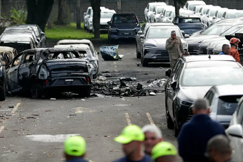 Burned vehicles and debris are seen after two helicopters reSundayportedly collided in midair and crashed into a car dealership parking lot in Rio de Janeiro, Brazil, , June 14, 2026. (AP Photo/Bruna Prado)