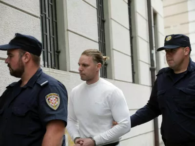 Robert DiCaprio aprila 2026 v spremstvu policistov. V malo manj glamurozni različici kot na objavah na spletnih družbenih omrežjih. 