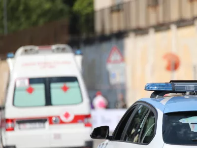 police car with blue flashing lights on it while escorting an ambulance to go to the hospital after the accident