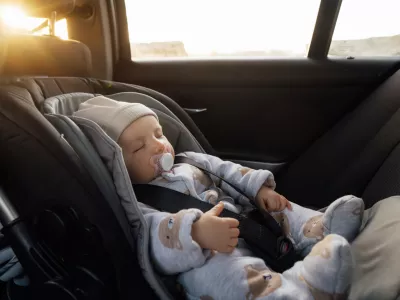 Baby sleeping in an infant car seat, safety travelling by car with little child. Little baby fastened with seat belt in safety car seat. Road trip lifestyle child care transportation rear-facing.
