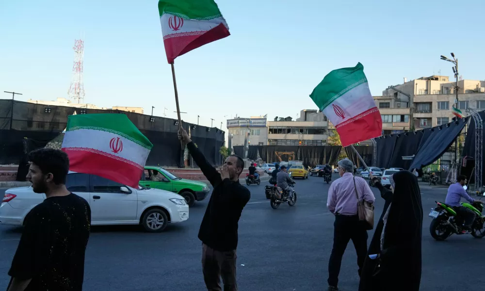 Demonstrators wave Iranian flags as they chant slogans against Iran and U.S. talks at the Islamic Revolution square in Tehran, Iran, Sunday, June 14, 2026. (AP Photo/Vahid Salemi)