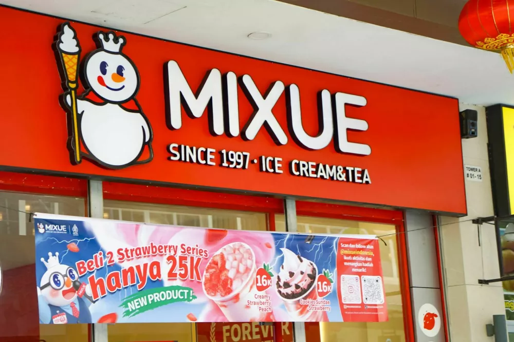 Batam, Indonesia, February 1, 2026: Ice cream shop with promotional banner, cartoon logo, and festive lantern in urban setting. / Foto: Rozita Turut
